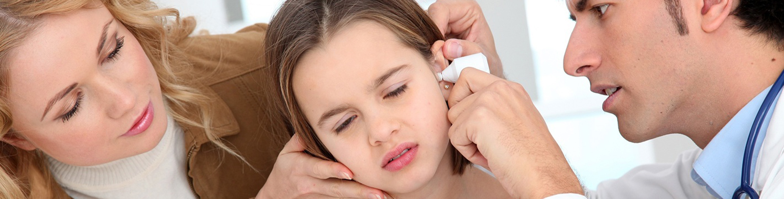 Djevojčica koju pregleda doktor zbog infekcije uha.