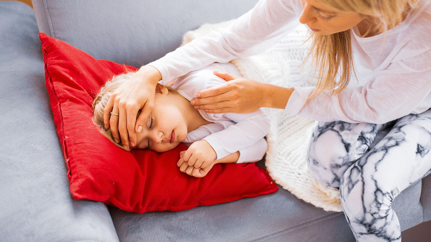 Majka mjeri temperaturu bolesnom djetetu.