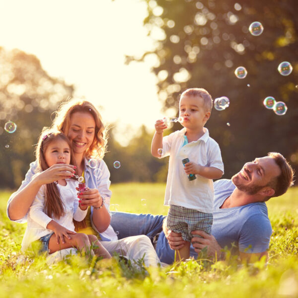 Bezbrižna, zdrava porodica se igra napolju.