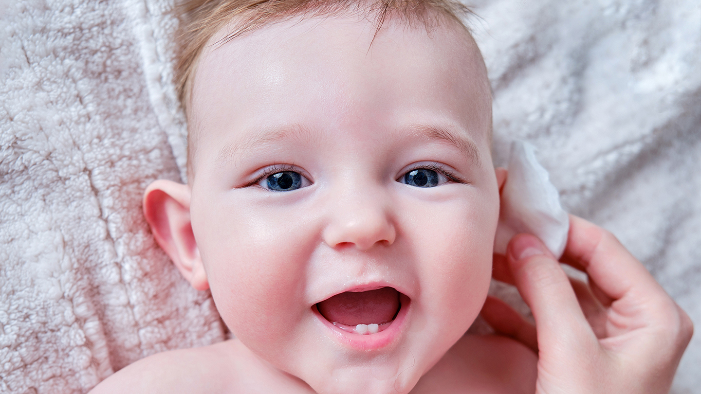 Beba s infekcijom uha na ćebetu.